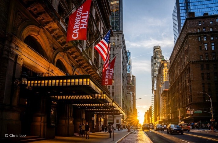 Carnegie Hall entrance with flags at sunset. © Chris Lee