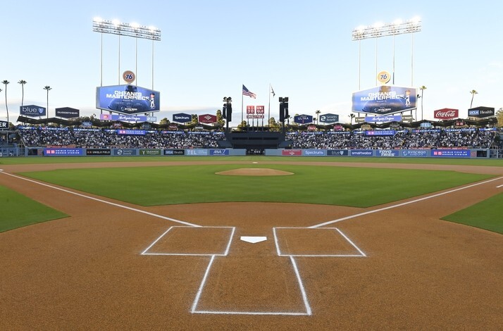 Dodger Stadium's field-level view from home plate, featuring the infield diamond, outfield scoreboard, and surrounding sponsor signage.