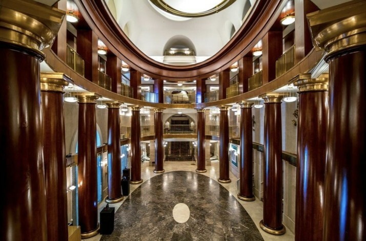 Elegant lobby with marble floor, tall columns, and golden accents in Teatro Real.