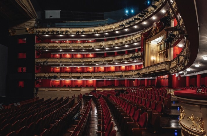 Wide view of Teatro Real’s auditorium with red seats and golden balconies.