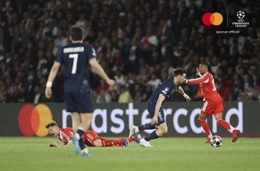 PSG midfielder dribbling past fallen Bayern player with Fabian Ruiz visible in background during Champions League semi-final.