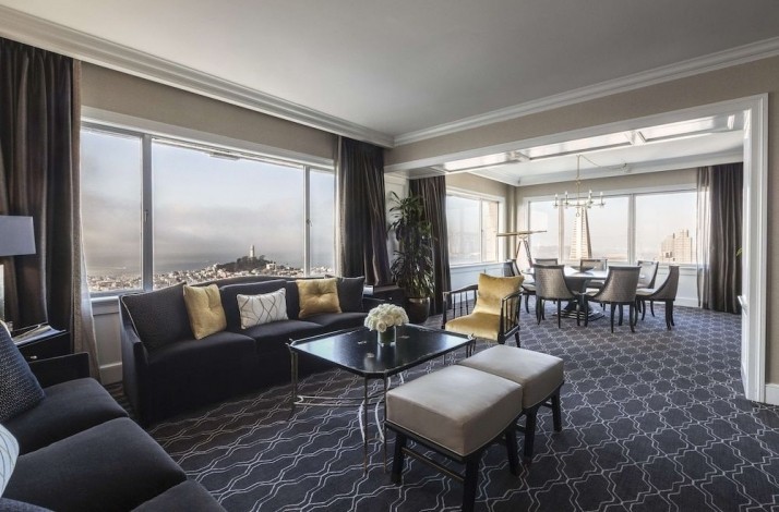 Living room at one of the suites of the Fairmont San Francisco hotel. The room is fully furnished in blue-beige colors and has panoramic windows. 