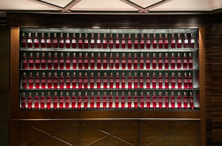Red bottles neatly arranged on shelves at Camparino in Galleria.
