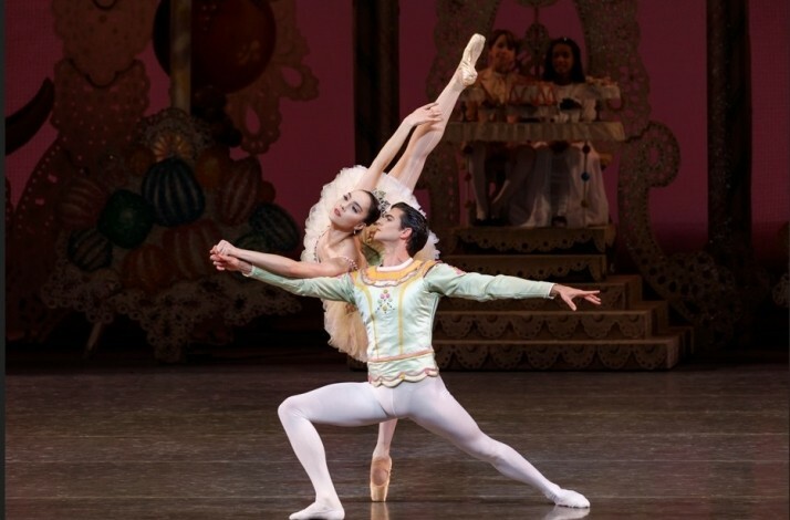 Dancers performing a duet in NYCB's The Nutcracker on a festive stage.