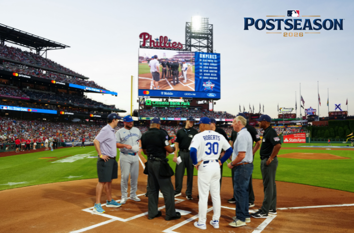 Pre-game home plate meeting at Citizens Bank Park featuring manager Dave Roberts (#30) and umpires; 'POSTSEASON 2026' logo upper-right.