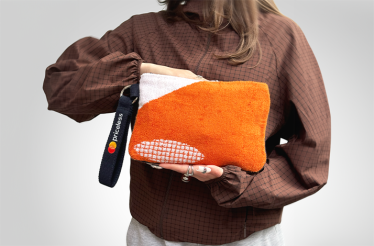 A person holding a pochette made from upcycled Roland-Garros 2025 towels.