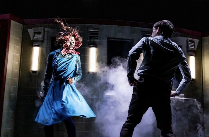 Scene from the Broadway's Stranger Things: The First Shadow performance: an unknown creature in blue dress approaching young man.