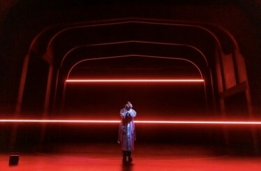 Scene from the Broadway's Stranger Things: The First Shadow performance: person standing in the middle of the stage and covering face with hands.
