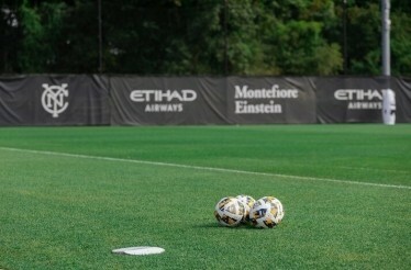 Three football balls on the field at NYCFC.