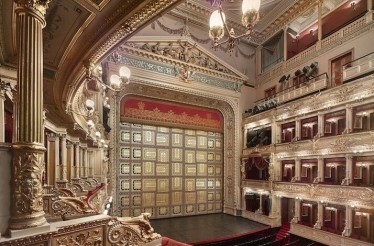 Interior of Prague National Theatre with ornate gold curtain.