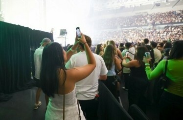 A girl films the Australian Open Live Final Stage on her phone.