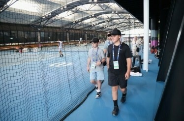 Guest walking past tennis courts during closed-door practice sessions