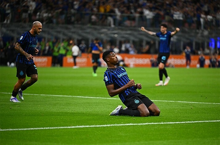  A soccer player sits on the ground, looking contemplative after a play during a match.