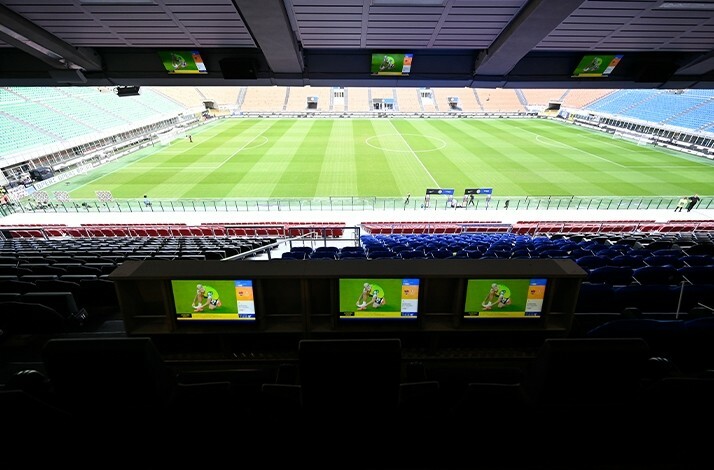 View on the football field with three monitors from sky box seats at San Siro Stadium.