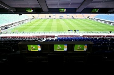 View on the football field with three monitors from sky box seats at San Siro Stadium.