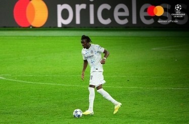 A player on the field during UEFA Champions League match with priceless logo on the banner in the background.