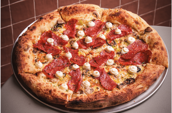 Gourmet pepperoni and mushroom pizza topped with cream swirls from Bar Bucce in Miami, Florida.