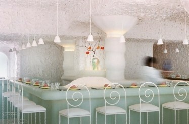CENTO Raw Bar's interior with white textured walls, pendant lights, and artistic vase decor