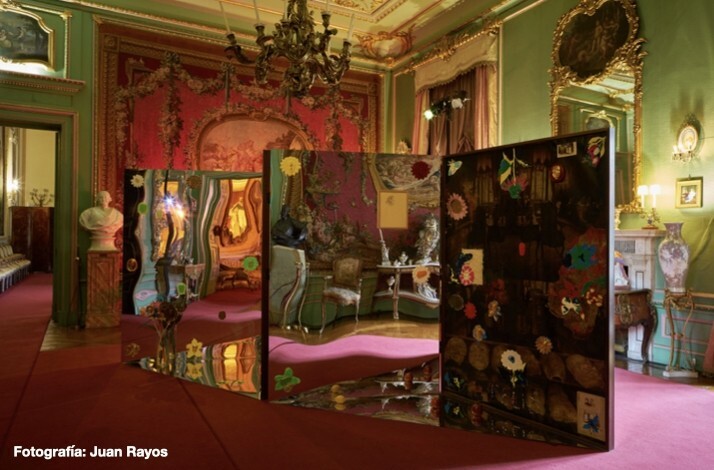 Artistic installation with mirrored panels and colorful decorations in a lavishly decorated room with red and green walls at Liria Palace.