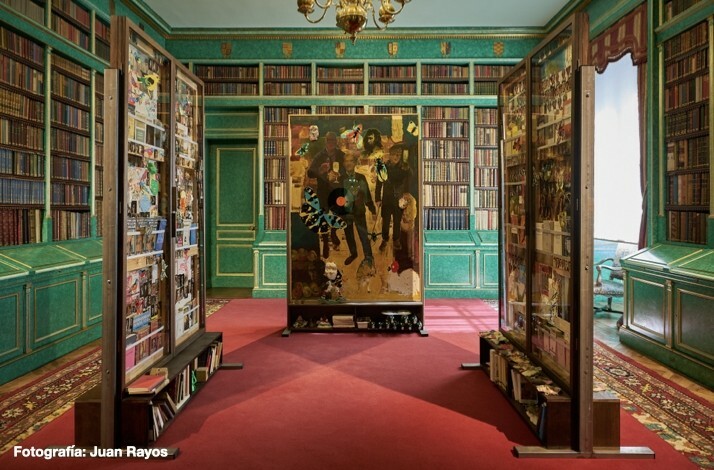 Library room at Liria Palace featuring green walls, shelves filled with books, and a central art piece with vibrant imagery.