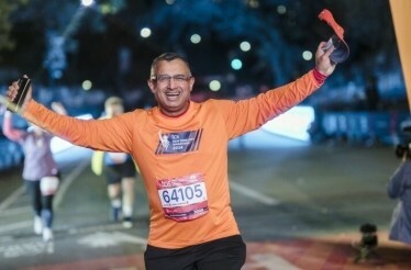 A man happily finishing his marathon run