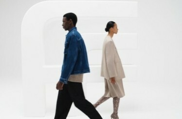 A man and a woman walking by in a fashion outfits.