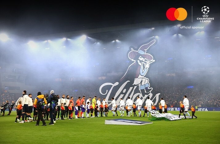 Football players lining up on the field before an UEFA Champions League match