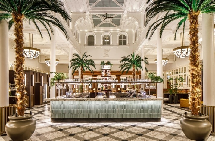 Elegant hotel bar with tall palm trees and bright lighting