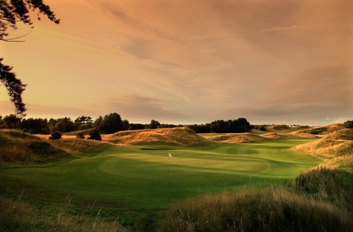 Royal Birkdale Golf Course at sunset, showing rolling dunes and a golf flag.