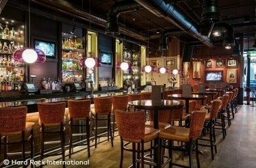 Interior of the Hard Rock Café with a range of tables and a bar counter. © Hard Rock International