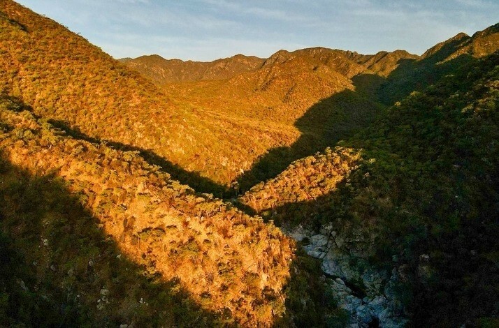 Aerial view of sunlit mountains and valleys in Sierra de la Laguna, Mexico.