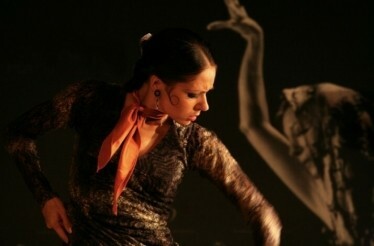 An artist in a black dress dancing flamenco