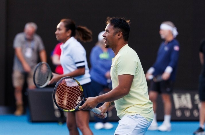 Two players in motion on a tennis court, actively holding their rackets and preparing for the next shot during gameplay.