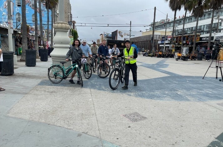 A group of people on the street holding Unlimited Biking bicycles.