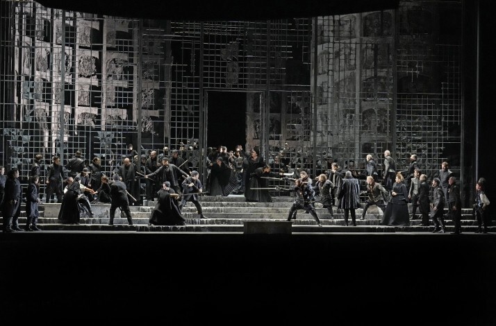 Actors interpreting a sword fight live on stage.
