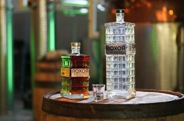 Two bottles of ROXOЯ Spirits and a glass for gin and bourbon tasting. 
