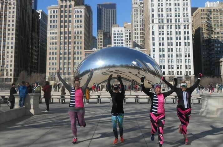 Four people exercising near the Chicago Cloud Gate monument.