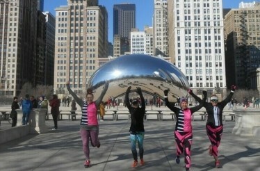 Four people exercising near the Chicago Cloud Gate monument.