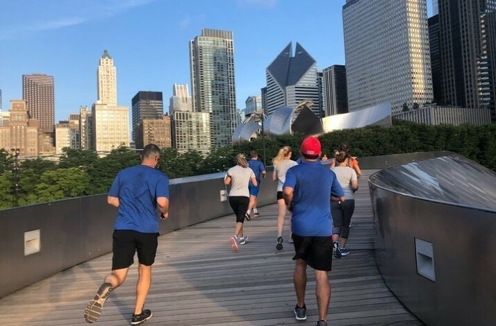 A group of people running through the center of Chicago on a guided 5K running tour.