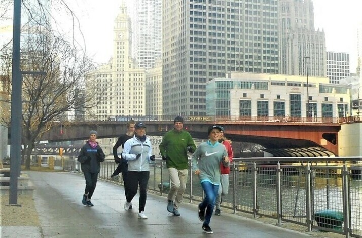 A group of people running through the center of Chicago on a guided 5K running tour.