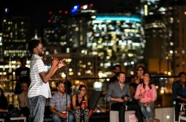 A person holding a mic at Sky High performing an standup show