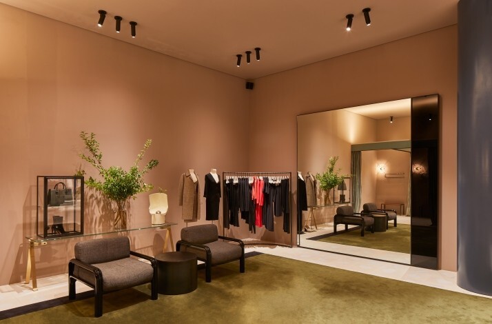 A stylish boutique with contemporary furniture, clothing racks, and minimalist decor.
