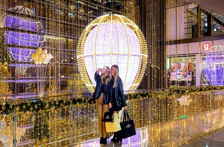Two people taking pictures near holiday decorations at Hudson Yards