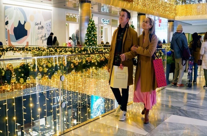 A couple walking through Hudson Yards looking at the holiday decorations