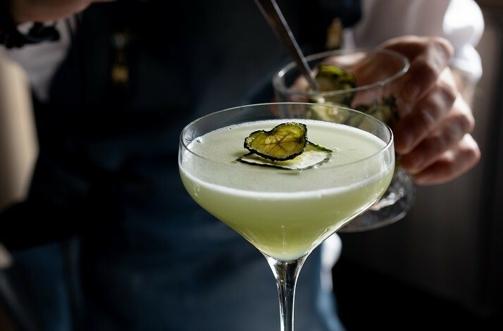 A bartender making a cocktail at Peak with Priceless