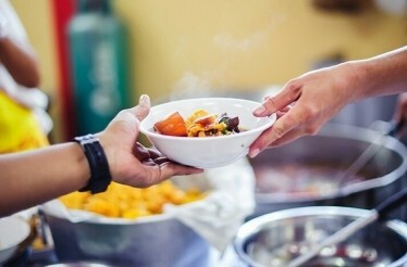 A bowl of food being handed to a customer at one of the Istanbul diners.