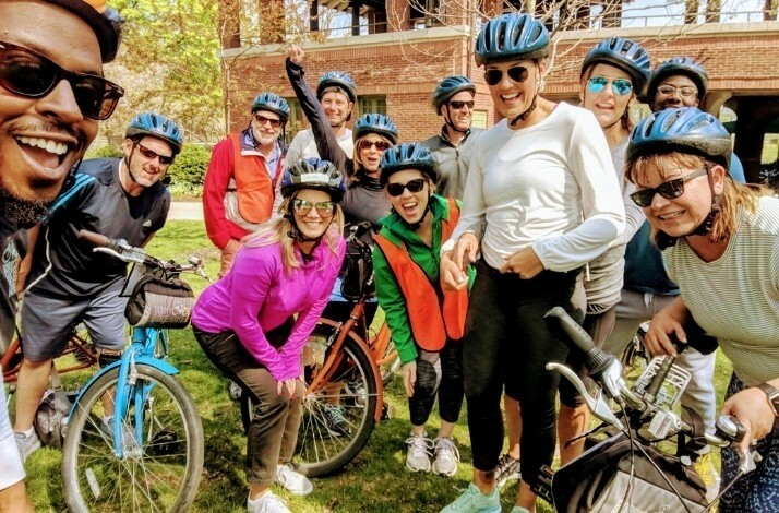 A group of persons with bicycles posing and smiling