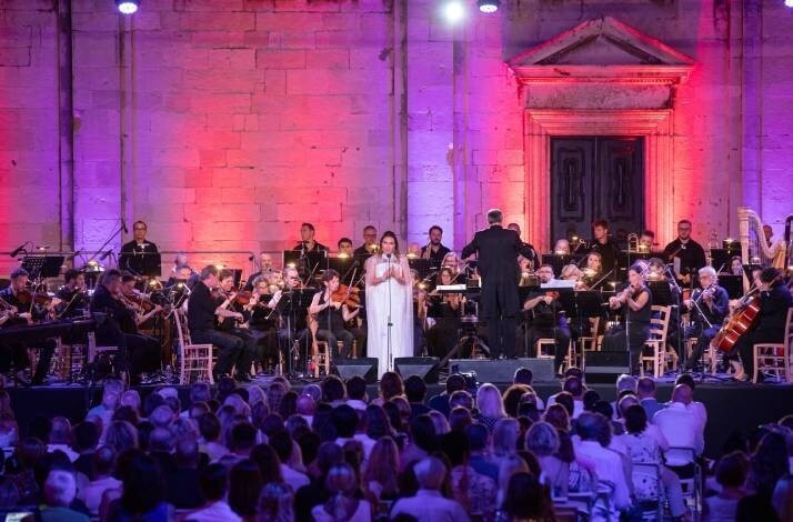 An opera gala at the Dubrovnik Summer Festival, featuring a soprano in a white dress performing with an orchestra.
