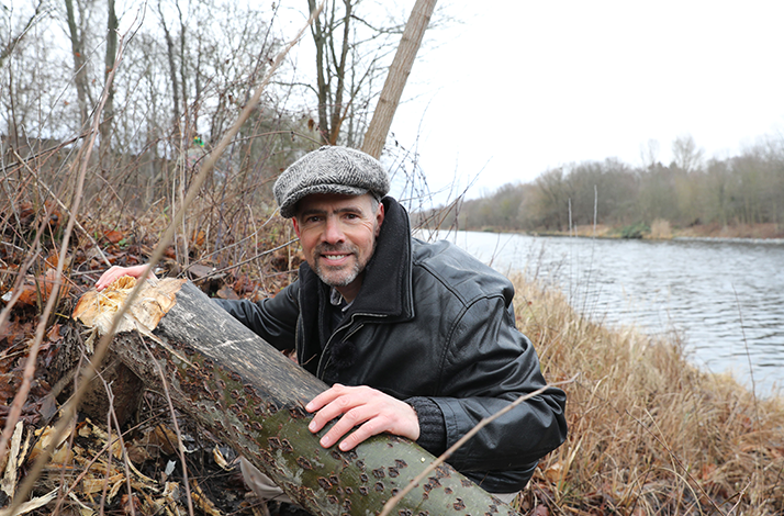 Wildlife expert Derk Ehlert poses beside a river.