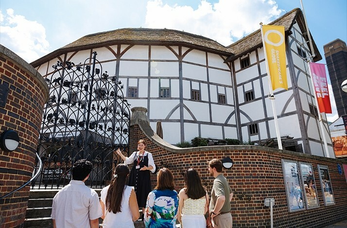 The guide enthusiastically shows visitors around Shakespeare's Globe.